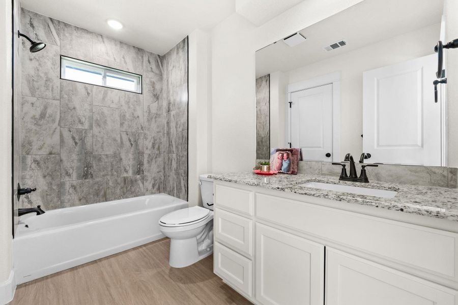 Full bathroom with shower / bath combination, vanity, and light wood-style floors