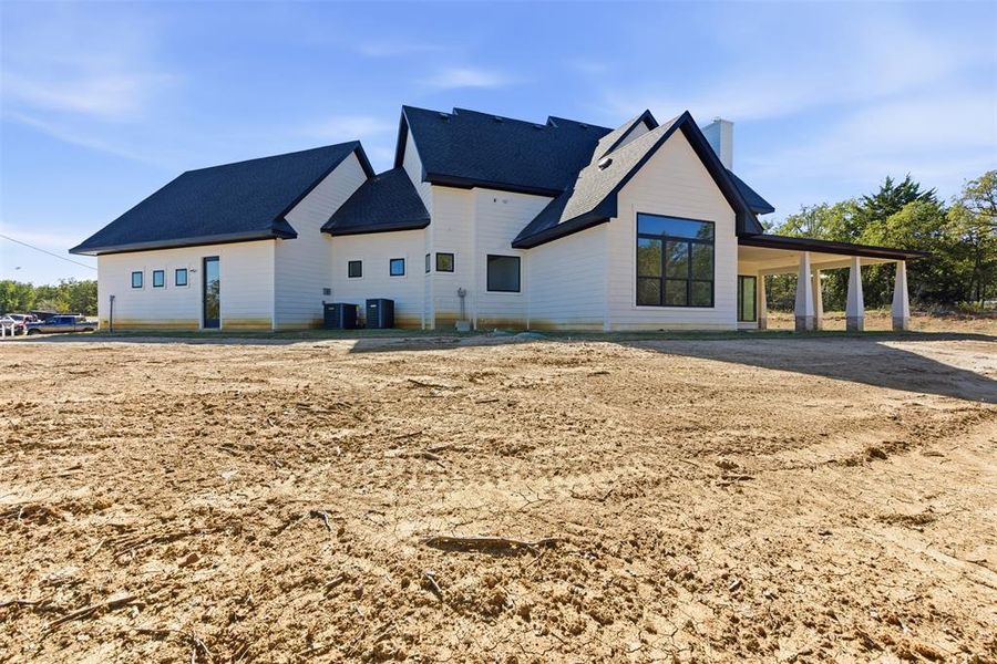 Back of house with a chimney, a patio, and a shingled roof Back of house with a chimney, a patio, and a shingled roof