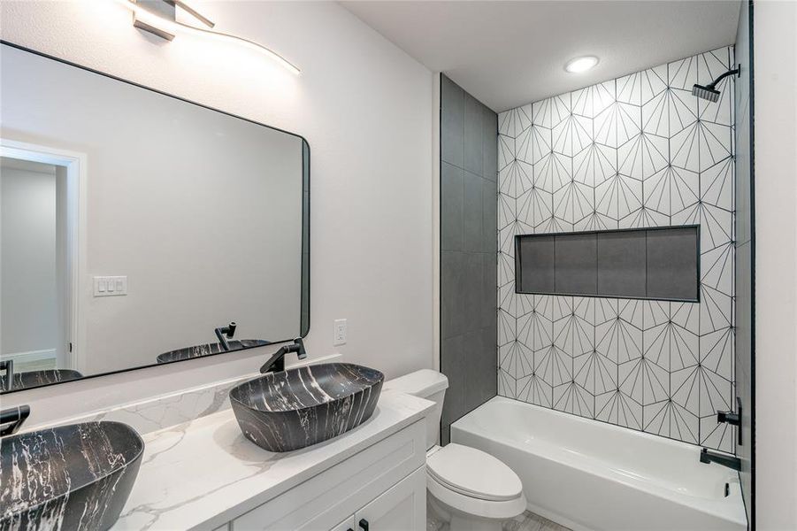 Full bathroom with vanity, toilet, and tiled shower / bath