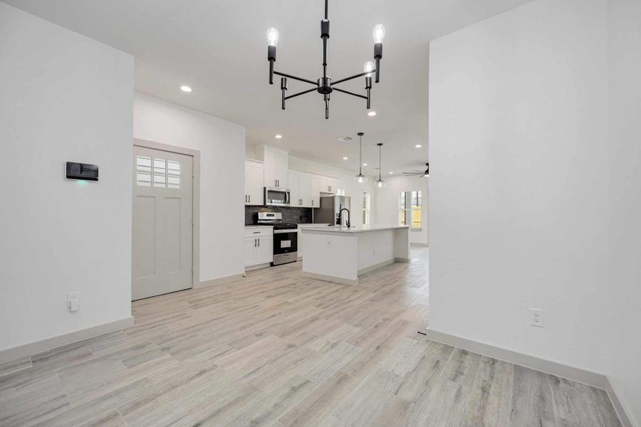 Dedicated dining space just off the kitchen with modern chandelier lighting and an open flow into the main living areas, making entertaining effortless.