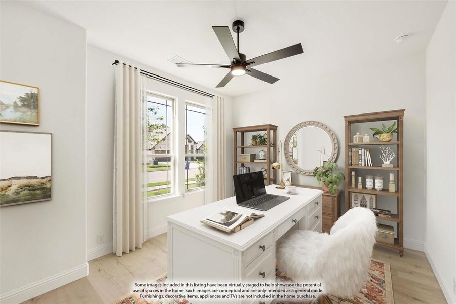 Home office with white desk, wood bookshelves, ceiling fan, and large windows with natural light