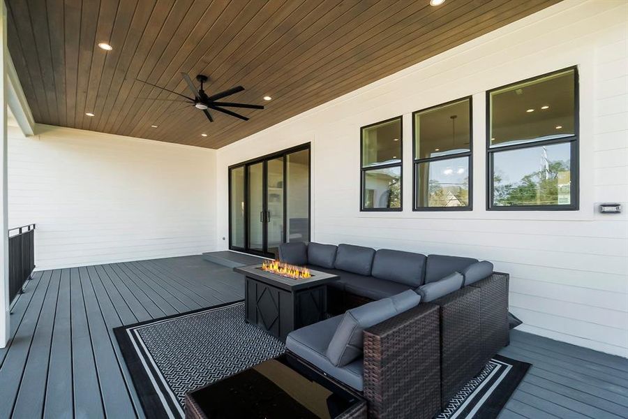 Expansive covered patio with wood-accented ceiling, recessed lighting, a ceiling fan, and ample space for outdoor entertaining