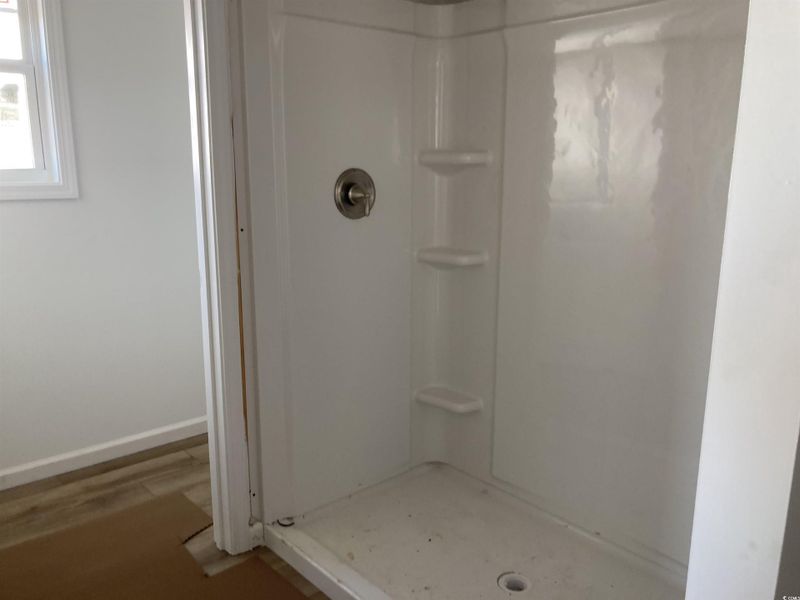 Bathroom with a stall shower and wood finished floors