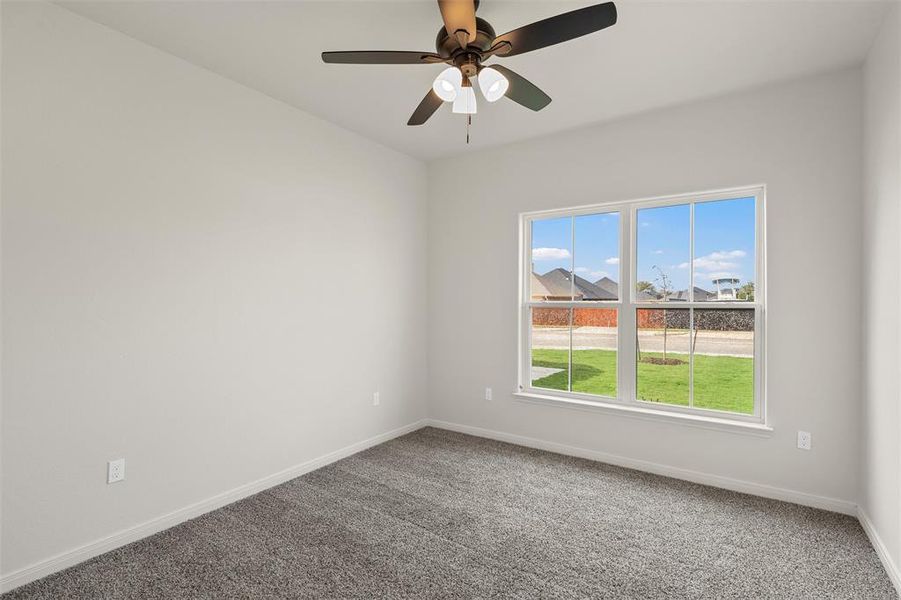 Carpeted spare room with baseboards and ceiling fan Carpeted spare room with baseboards and ceiling fan