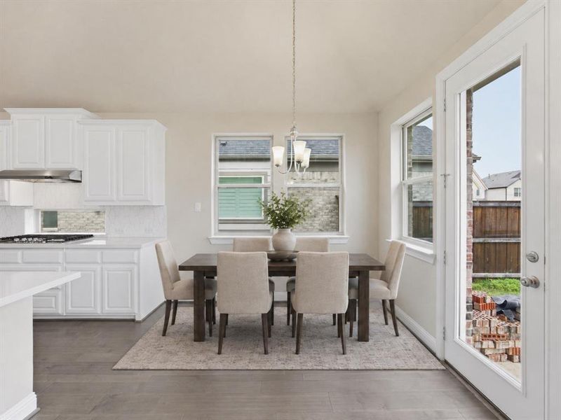 Dining area featuring a contemporary chandelier, multiple windows, and wood-finish flooring