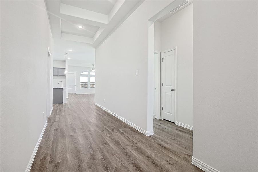 Hallway with light wood-style flooring and recessed lighting Hallway with light wood-style flooring and recessed lighting
