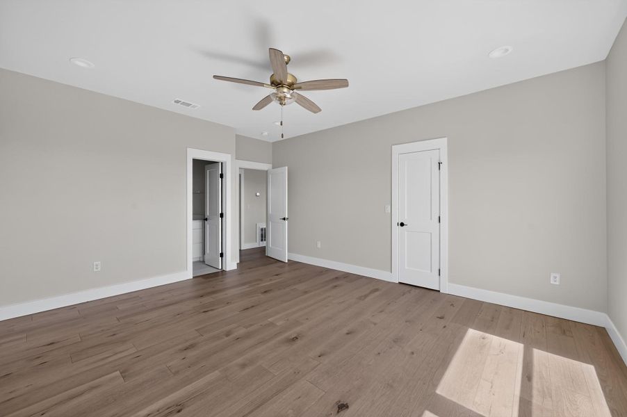 Rich hardwood flooring anchors this versatile bedroom space filled with natural light.