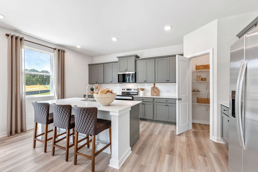 A kitchen with a dining table and a large window. A kitchen with a dining table and a large window.