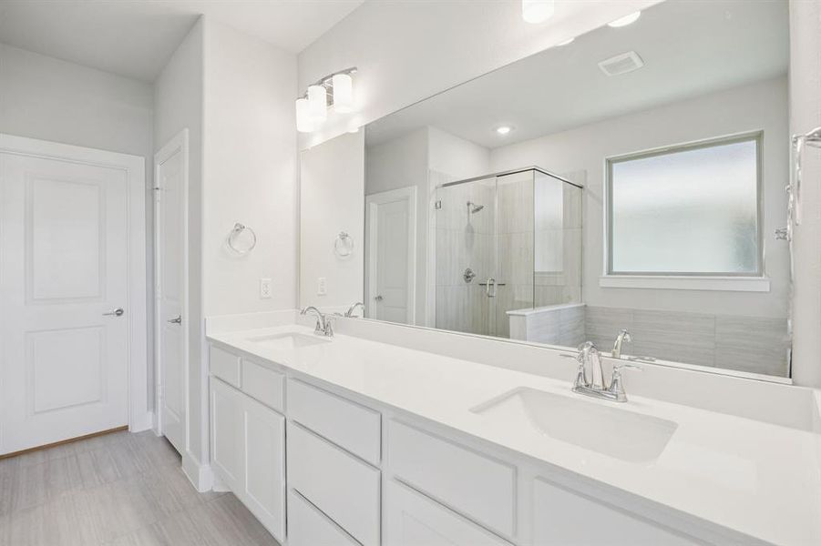 Bathroom featuring double vanity and a shower stall
