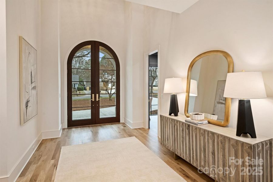 Step inside and take in the magnificent two-story foyer, where natural light pours in through expansive windows, highlighting the open floor plan.