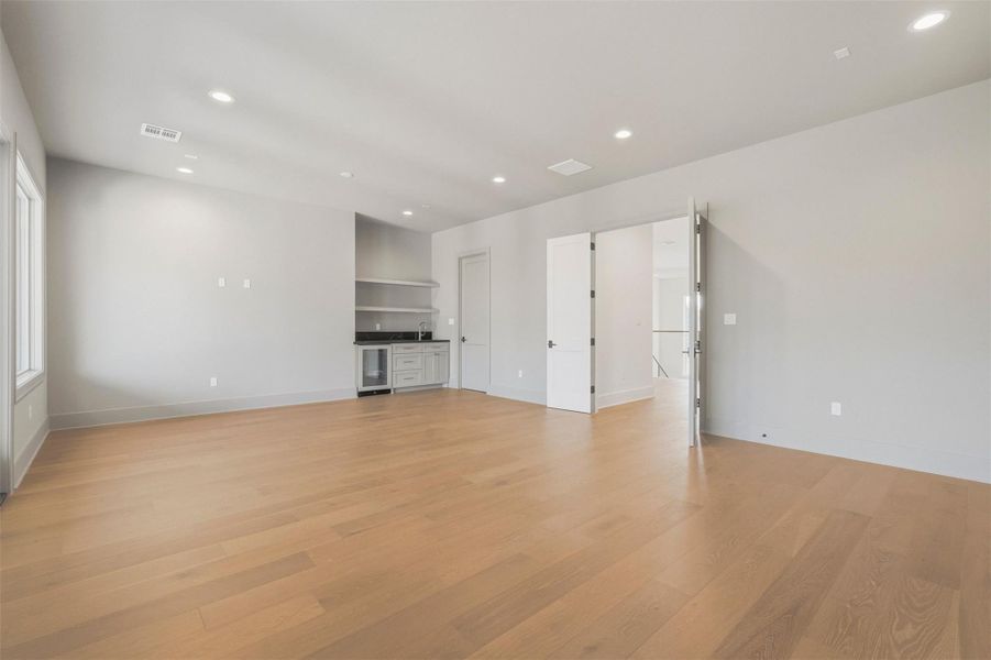 Down the hallway, this second-floor game room showcases a built-in bar, perfectly designed for large gatherings and leisure in style. Down the hallway, this second-floor game room showcases a built-in bar, perfectly designed for large gatherings and leisure in style.