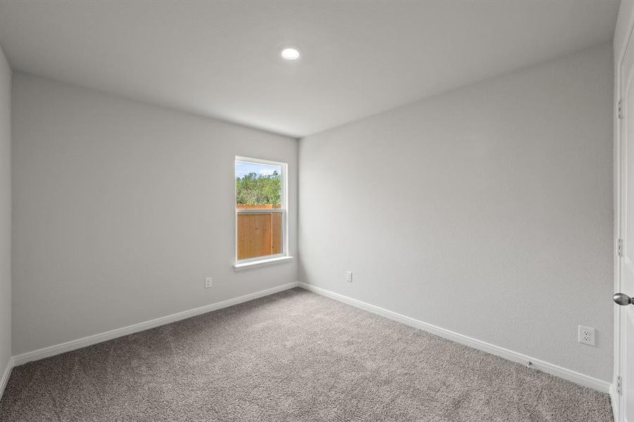 Carpeted spare room featuring baseboards Carpeted spare room featuring baseboards