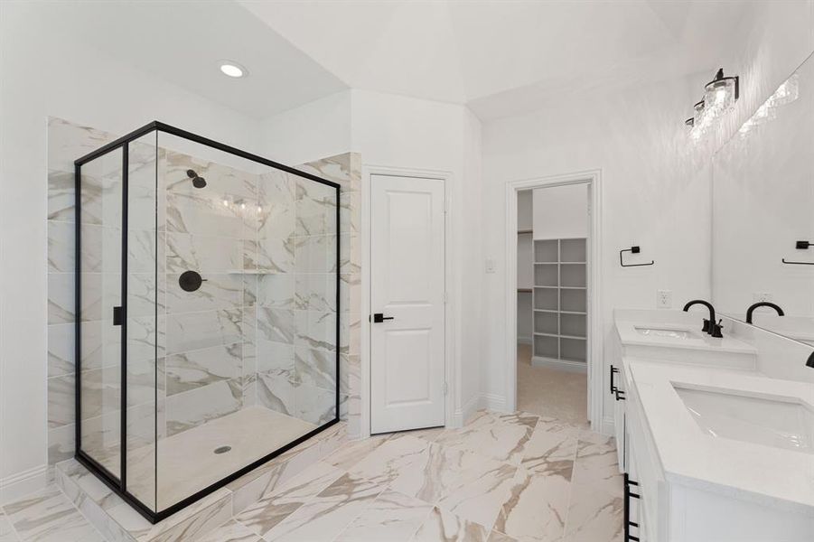 Full bathroom featuring a walk in closet, light marble finish floors, a marble finish shower, double vanity, and recessed lighting Full bathroom featuring a walk in closet, light marble finish floors, a marble finish shower, double vanity, and recessed lighting
