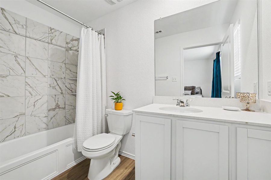 Bathroom featuring a white vanity with a quartz countertop and integrated sink