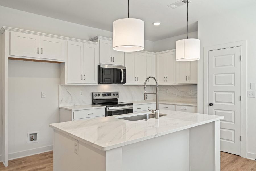 Modern kitchen featuring white cabinetry and light-toned countertops