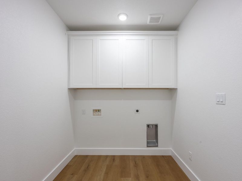 Upper cabinetry provides plenty of space to store cleaning supplies and linens. Durable luxury vinyl flooring continues the clean, modern aesthetic. Upper cabinetry provides plenty of space to store cleaning supplies and linens. Durable luxury vinyl flooring continues the clean, modern aesthetic.