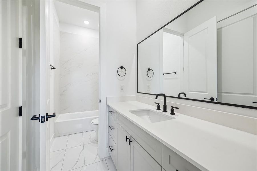 Beautiful quartz, and designer tile in Another one of your bathrooms with shower/tub.