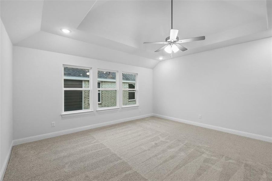 Carpeted spare room featuring recessed lighting, lofted ceiling, a ceiling fan, and baseboards