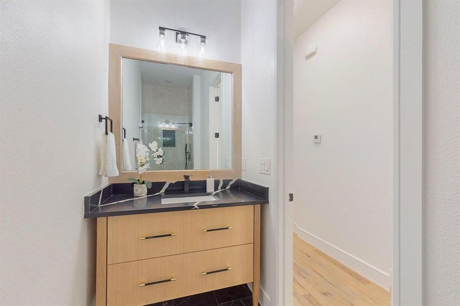 Bathroom featuring hardwood / wood-style floors, an enclosed shower, and vanity