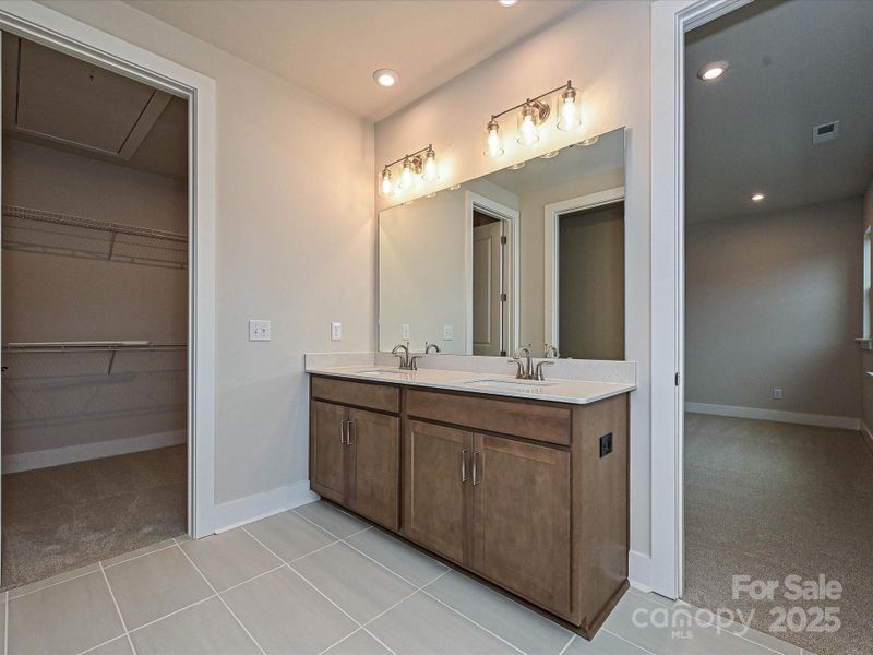 Dual vanity with loads of storage and modern floor tile.