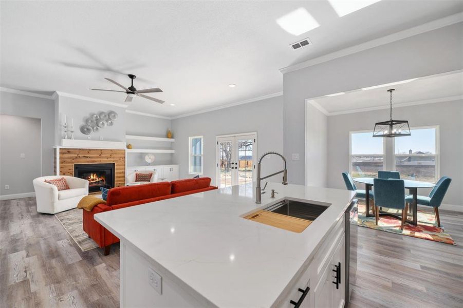 Kitchen with a kitchen island with sink, sink, and hanging light fixtures