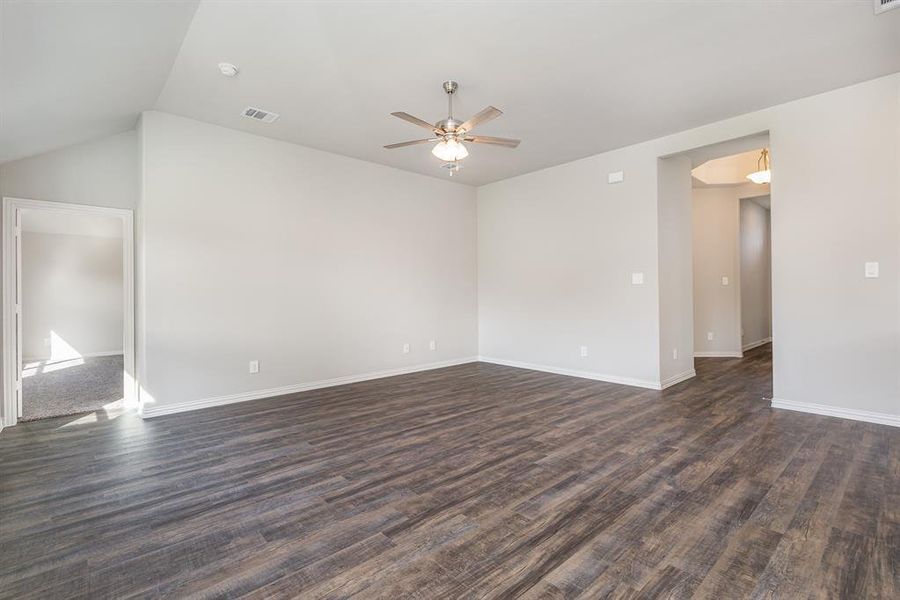 Unfurnished room with ceiling fan, dark hardwood / wood-style flooring, and lofted ceiling