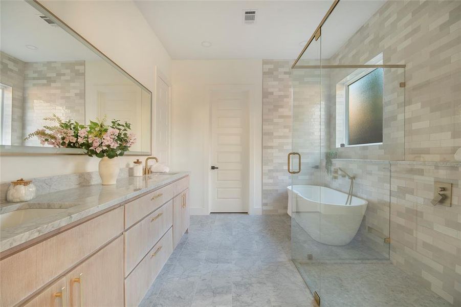 Bathroom with double vanity, a soaking tub, a stall shower, and tile walls Bathroom with double vanity, a soaking tub, a stall shower, and tile walls