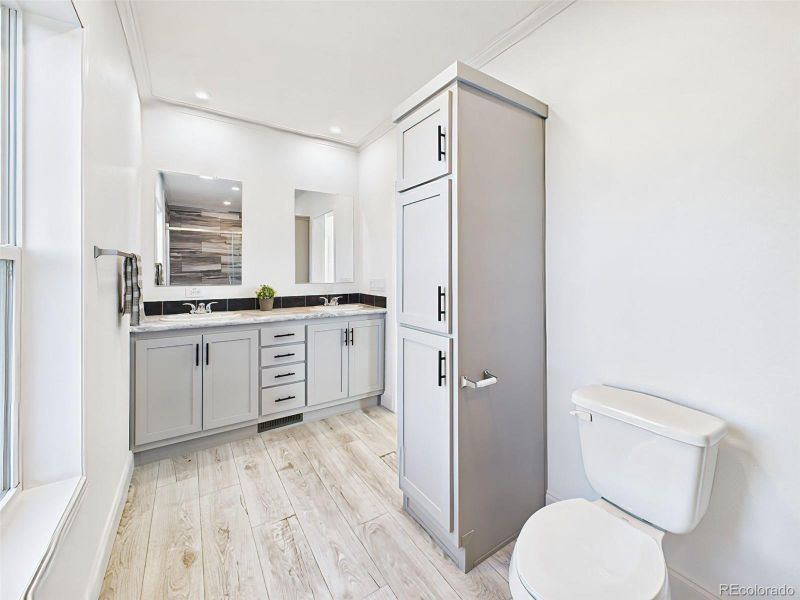 Bright primary bath with modern finishes, large mirror, and high ceilings. Bright primary bath with modern finishes, large mirror, and high ceilings.