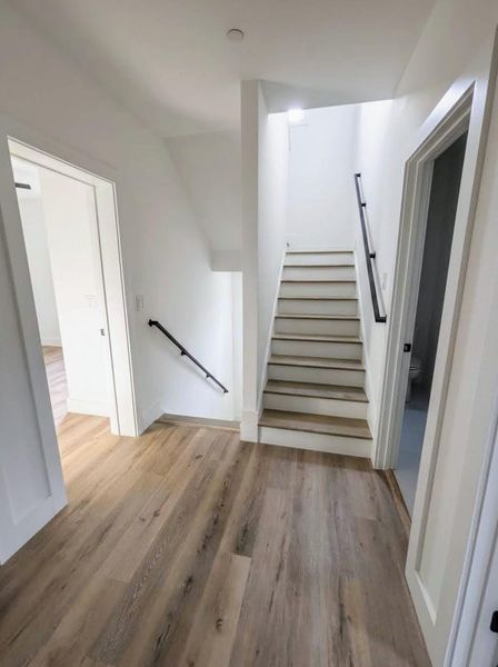 Stairs featuring wood finished floors