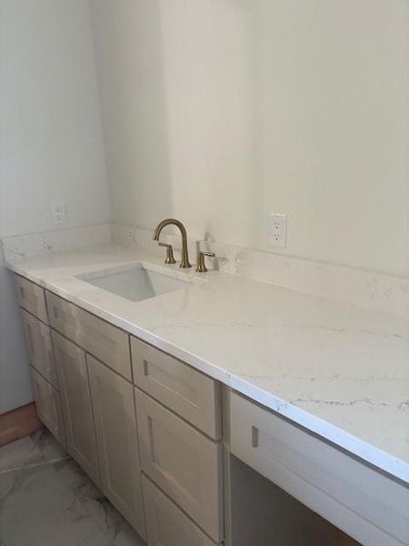 Bathroom with vanity and light marble finish floors