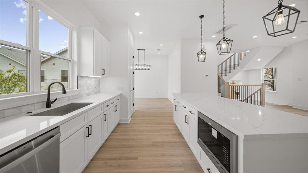 This kitchen includes under cabinet lighting and outlets, and luxury vinyl plank floors.