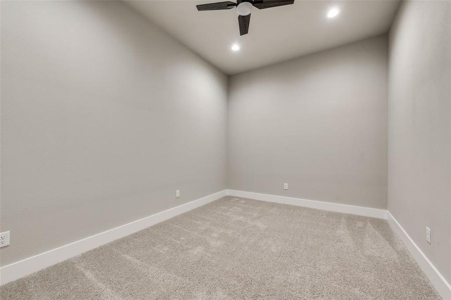 Carpeted empty room featuring ceiling fan