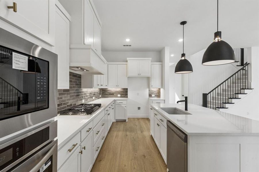 Classic white cabinetry, beautiful countertops and designer backsplash effortlessly pair with contemporary stainless steel to create a dream kitchen for the ages!