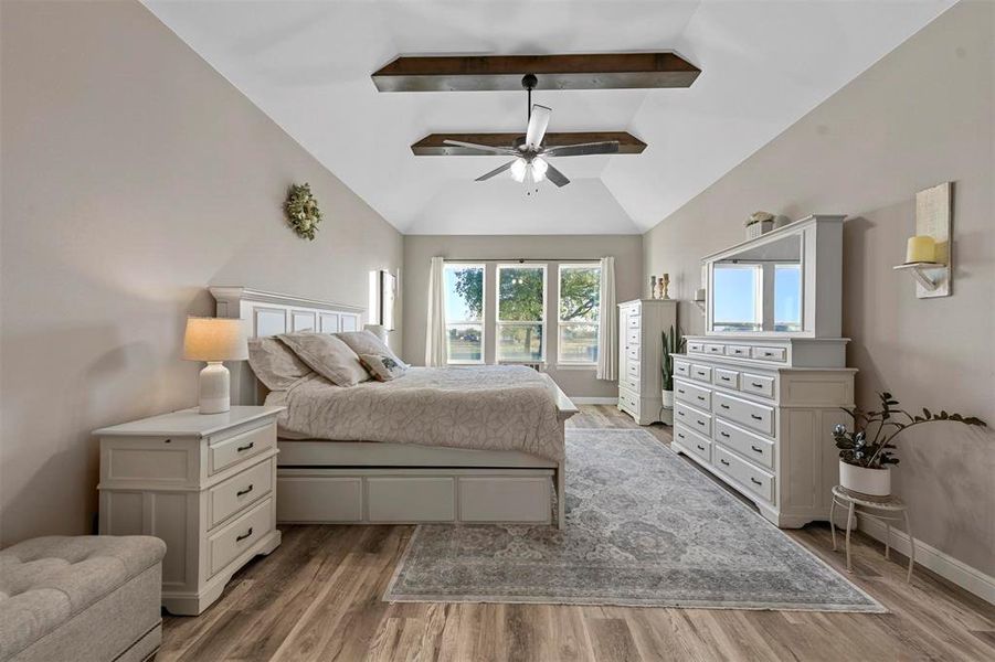 Bedroom with vaulted ceiling with beams, ceiling fan, and light wood-type flooring