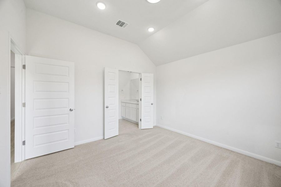 Unfurnished bedroom featuring lofted ceiling, light carpet, and recessed lighting