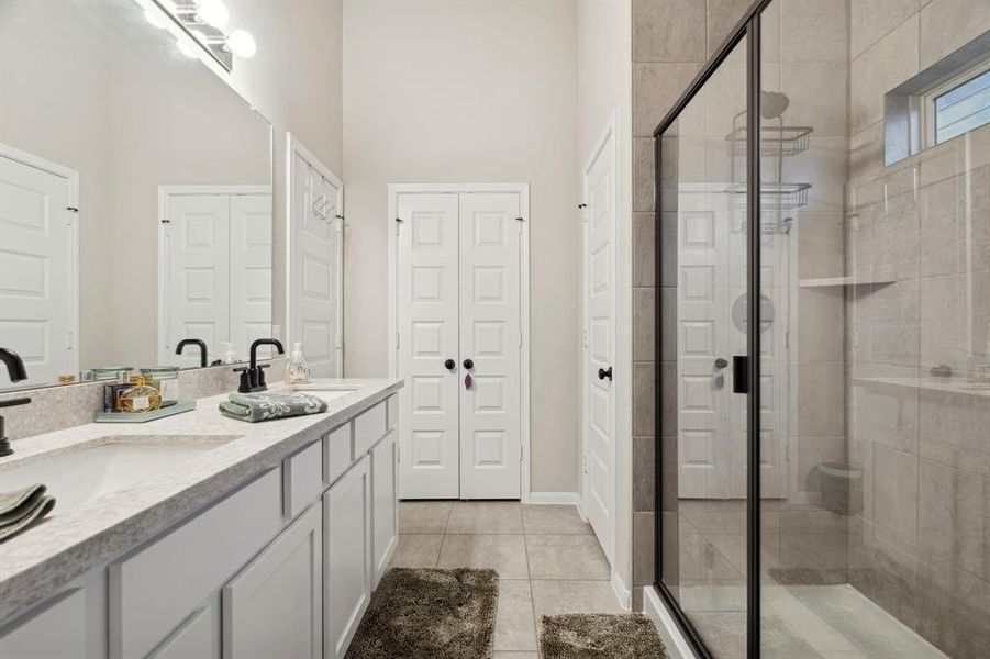 Primary room features an en-suite bathroom with double sinks, a luxurious soaking tub, and a separate walk-in shower, providing a spa-like experience at home.