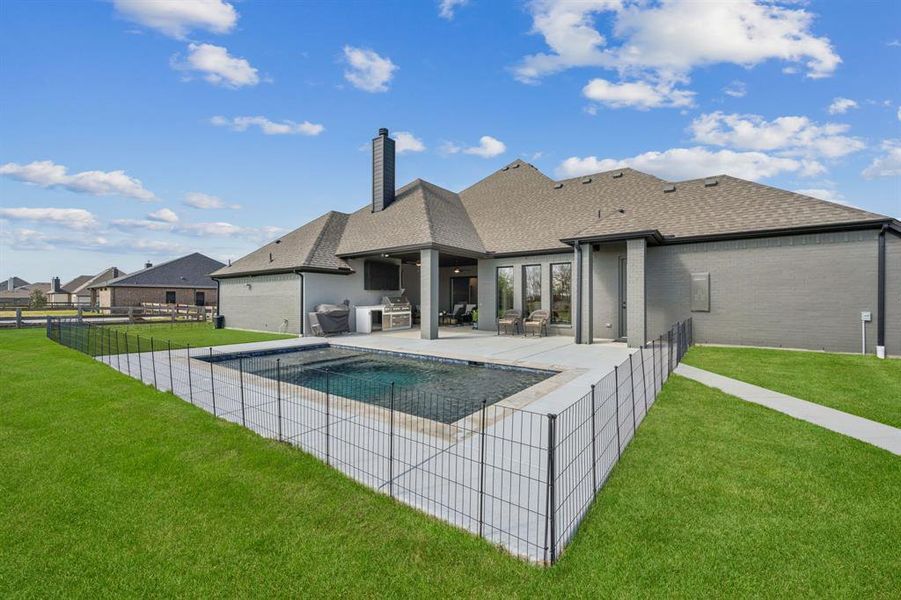 Back of property featuring a patio area, a shingled roof, brick siding, a chimney, and a fenced backyard