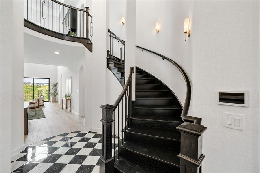 Stairs with recessed lighting, tile patterned flooring, a towering ceiling, and arched walkways Stairs with recessed lighting, tile patterned flooring, a towering ceiling, and arched walkways