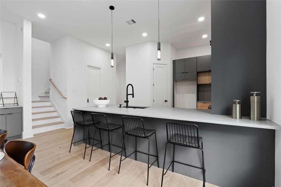 Minimalism takes center stage in this kitchen composition, defined by smooth surfaces, refined textures, and seamless storage. The expansive island invites connection, whether for morning routines or evening hosting, while the surrounding design prioritizes flow and simplicity. It’s a kitchen that feels effortlessly modern—designed not to impress loudly, but to endure beautifully.
