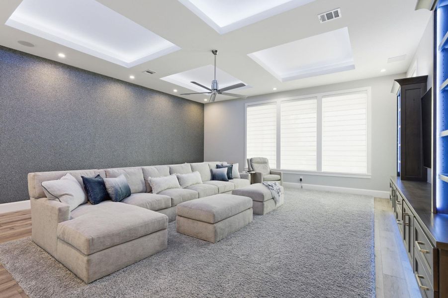 Living room with an accent wall, light wood-style floors, ceiling fan, and recessed lighting