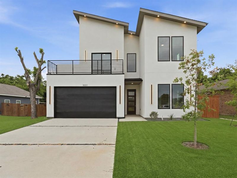 Contemporary facade featuring a prominent second-story balcony with metal railing, an integrated two-car garage with a dark door, and a sleek entry door with frosted glass panels Contemporary facade featuring a prominent second-story balcony with metal railing, an integrated two-car garage with a dark door, and a sleek entry door with frosted glass panels
