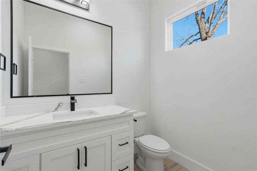 Half bath with vanity and light wood-type flooring Half bath with vanity and light wood-type flooring