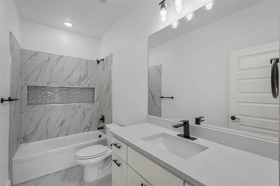 Full bathroom with vanity, toilet, and tiled shower / bath