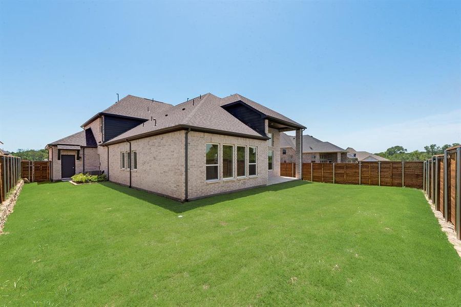 Rear view of property featuring a fenced backyard, brick siding, a patio, and roof with shingles Rear view of property featuring a fenced backyard, brick siding, a patio, and roof with shingles