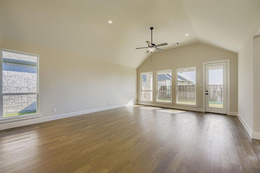 Unfurnished room featuring lofted ceiling, hardwood / wood-style flooring, a ceiling fan, and recessed lighting Unfurnished room featuring lofted ceiling, hardwood / wood-style flooring, a ceiling fan, and recessed lighting