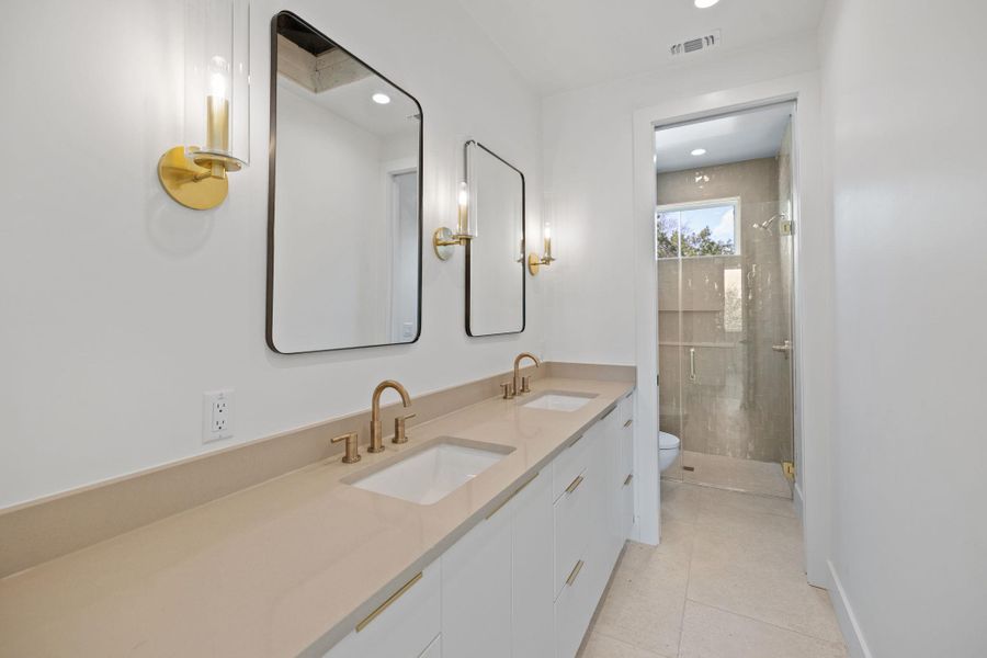 Full bathroom featuring a shower stall, double vanity, light tile patterned floors, and recessed lighting Full bathroom featuring a shower stall, double vanity, light tile patterned floors, and recessed lighting