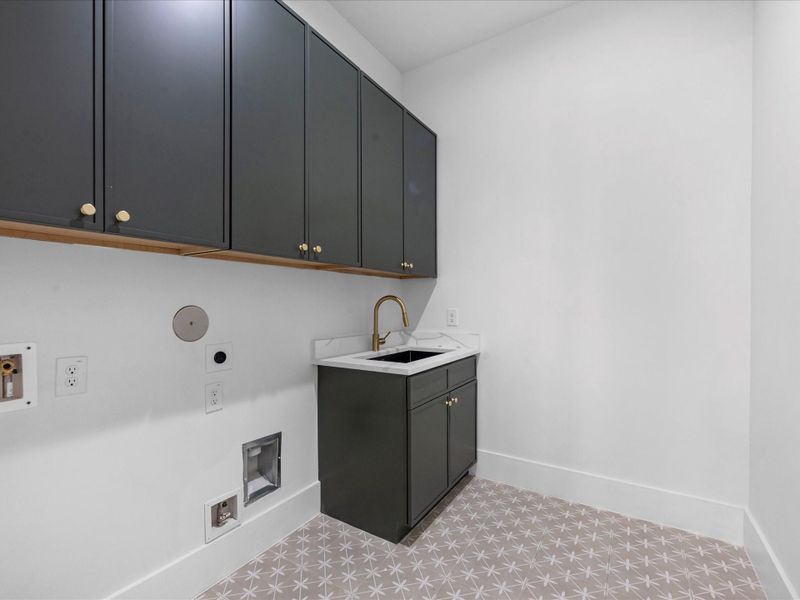 Utility room has a sink and built ins for functionality.
