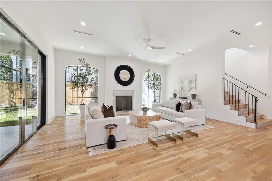 The Family Room with oversized arched windows and a wood burning fireplace (plastered mantel to be installed this week). A set of double doors lead you to the outdoors.