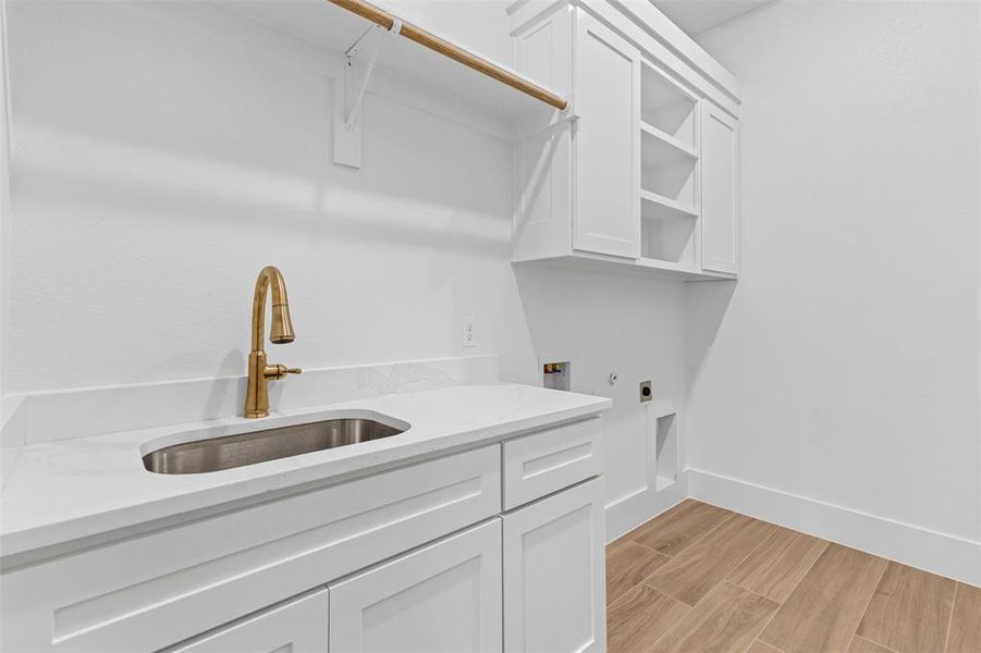 Laundry area with wood finish floors, cabinet space, washer hookup, and hookup for an electric dryer