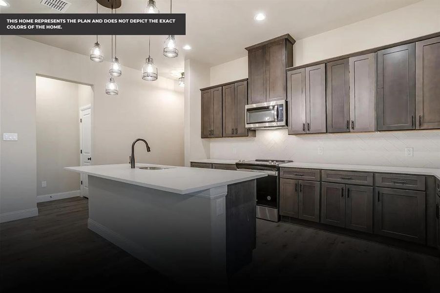 Kitchen featuring stainless steel appliances, dark wood-type flooring, sink, pendant lighting, and an island with sink